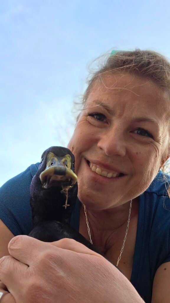 Melanie holding one of her ducks, Bridging the gap between research and reality for backyard flocks.